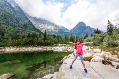 Küçük kız İtalya dağlarına bakıyor.