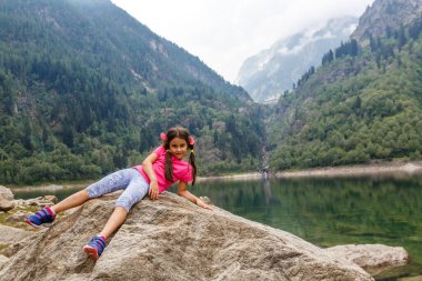 Küçük kız İtalya dağlarına bakıyor.