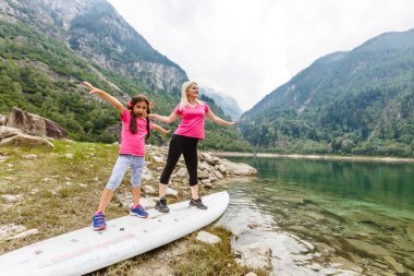Anne ve kızı İtalya Gölü yakınlarındaki dağlarda yürüyorlar.