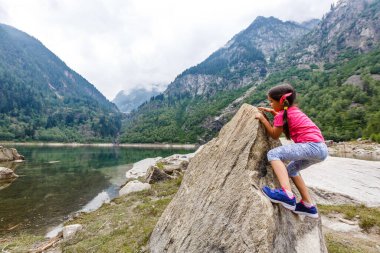 Küçük kız İtalya dağlarına bakıyor.