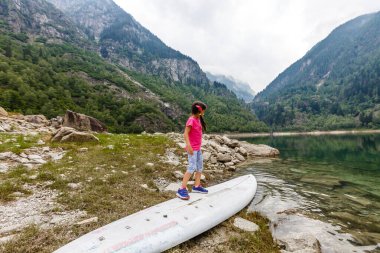 Küçük kız İtalya dağlarına bakıyor.
