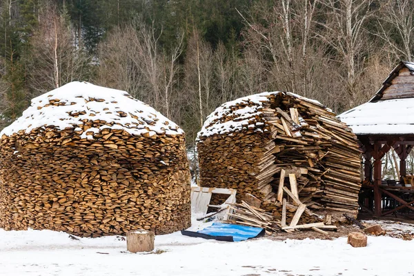 Firewood stacked in winter. Wood pile with snow stacked for firewood. Chopped stock of firewood under snow. Piles of snow covered firewood at cold winter day — Stock Image Firewood Stacked Winter Wood Pile Snow Stacked Firewood Chopped Stock Royalty Free Stock Images