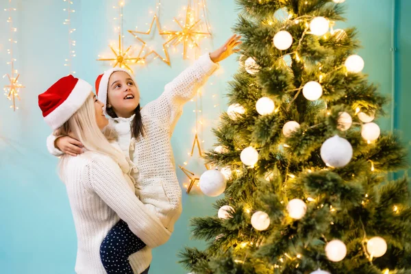 Menina Ajudando Sua Mãe Decorar Árvore Natal Segurando Algumas Bugigangas — Fotografia de Stock