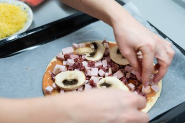 Küçük kız evde pizza yapıyor.