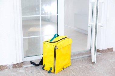 Evin girişinin yanında bir termo çanta var. Yemek dağıtım servisi.