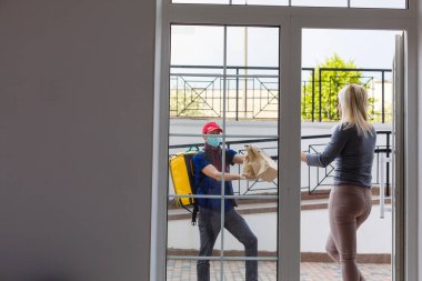 Sırt çantalı teslimatçı ve ofiste gülümseyen bir kadın.