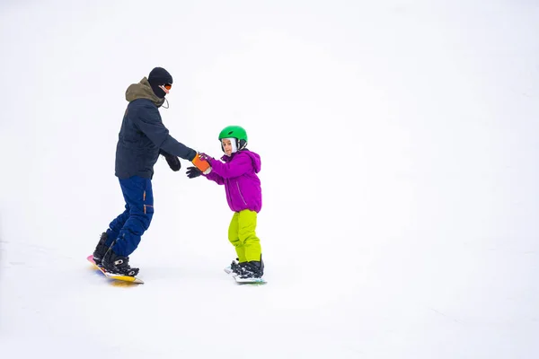 在高山滑雪场的冷风日 父亲教小女儿滑雪板 — 图库照片