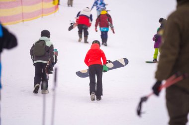 Turistler tatillerde kayak ve snowboard oynamayı severler..