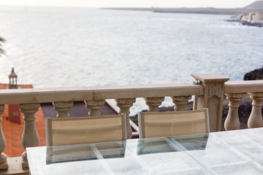 Arka planda günbatımı olan deniz kenarındaki bir restoranın masası. Konsept: Yaz, özgürlük, restoran.