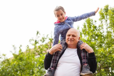 Küçük kız büyükbabasıyla parkta vakit geçiriyor..