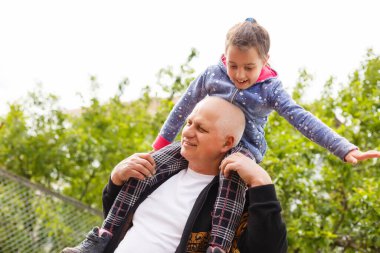 Küçük kız büyükbabasıyla parkta vakit geçiriyor..