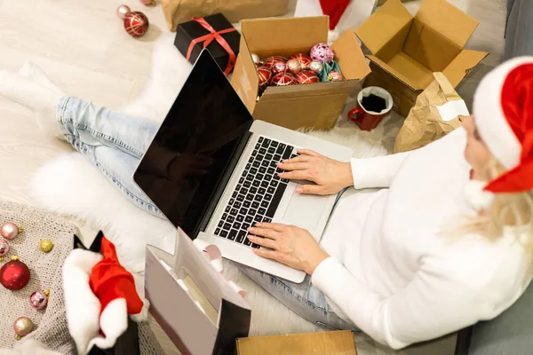 크리스마스 온라인 노트북을 구매자 화면에 여인은 마시고 선물을 엑스레이 준비하며 — 스톡 사진