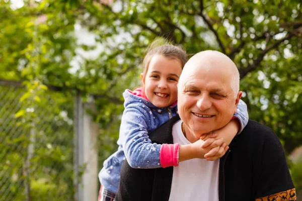 Küçük kız büyükbabasıyla parkta vakit geçiriyor..