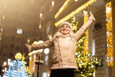Noel pazarında gezen bir kız akşamları tatil ışıklarıyla süslenir. Büyük şehirde mutlu hissediyorum. Kış tatillerini Kızıl Meydan, Moskova, Rusya 'da geçirmek.
