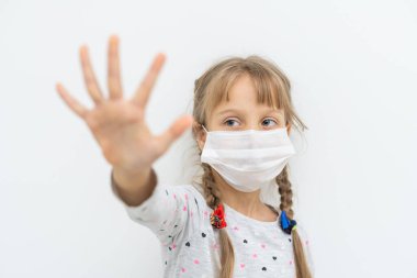 Covid-19 ve Hava kirliliği pm2.5 konsepti. PM2.5 'u korumak için maske takan küçük kız ve Corona virüsünü durdurmak için el hareketi yapan eller..