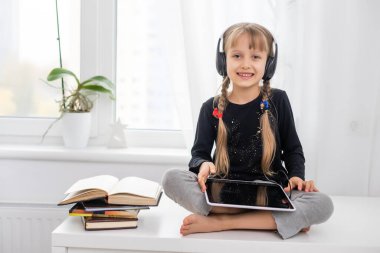 eğitim, okul, teknoloji ve internet konsepti - evde tabletli küçük kız çocuğu