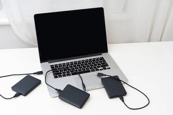 External backup disk hard drive connected to laptop. High quality photo