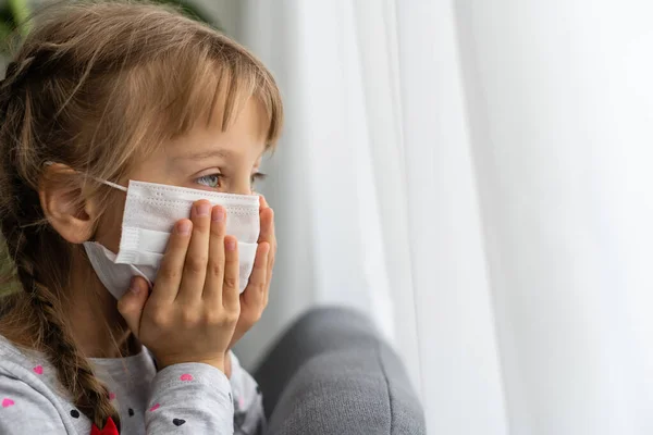 Masked child - protection against influenza virus. Little Caucasian girl wearing mask for protect pm2.5. Biological weapons. baby on a gray background with copy space. epidemic, pandemic.