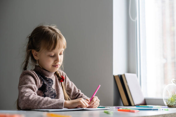 Little girl is doing his homework for elementary school.