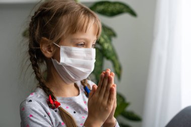 Coronavirüs salgını sırasında maske takan beyaz hasta küçük bir kız.