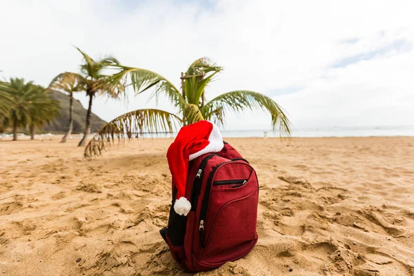 Chapéu Papai Noel Uma Mochila Vermelha Turística Contra Mar Azul — Fotografia de Stock