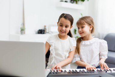 Piyano çalan kız için ev müziği dersi. Karantina sırasında çocuk için evde aktivite fikri. Müzik konsepti