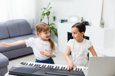 Piyano çalan kız için ev müziği dersi. Karantina sırasında çocuk için evde aktivite fikri. Müzik konsepti
