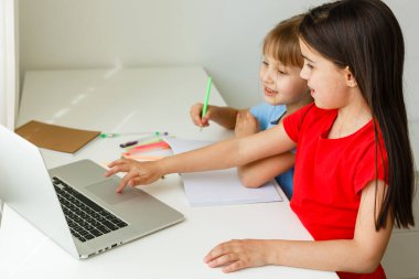İki tatlı kız kardeş evde birlikte ders çalışıyor. Çocuklar için eğitim.