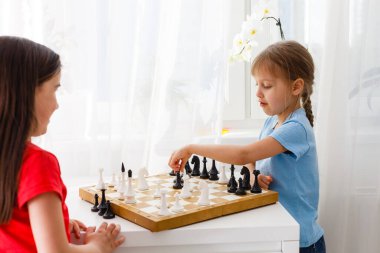 Evde satranç oynayan iki sevimli çocuk.