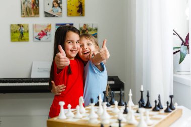 Evde satranç oynayan iki sevimli çocuk.