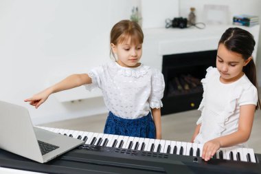 Piyano çalan kız için ev müziği dersi. Karantina sırasında çocuk için evde aktivite fikri. Müzik konsepti