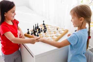 Evde satranç oynayan iki sevimli çocuk.