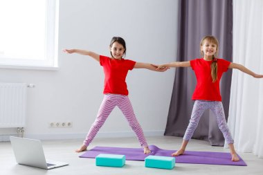 Güzel atletik genç kızlar evde yoga yapıyorlar.