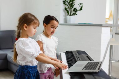 Piyano çalan kız için ev müziği dersi. Karantina sırasında çocuk için evde aktivite fikri. Müzik konsepti