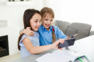 İnternette okuyan iki küçük kız. Çevrimiçi Uzaklık Öğrenme, e-öğrenme, konsept