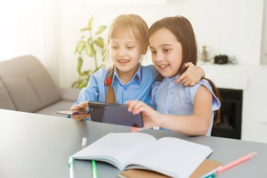 Evde öğreniyorum, evde öğreniyorum. Küçük çocuklar evde bilgisayarla online öğrenim görüyorlar. Karantina ve Sosyal Mesafe.