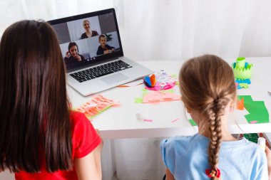 Evde öğreniyorum, evde öğreniyorum. Küçük çocuklar evde bilgisayarla online öğrenim görüyorlar. Karantina ve Sosyal Mesafe.