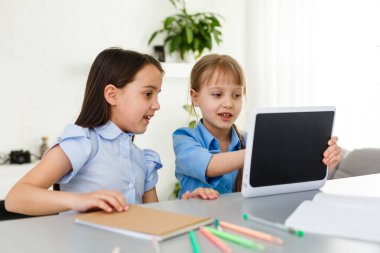 Evde öğreniyorum, evde öğreniyorum. Küçük çocuklar evde bilgisayarla online öğrenim görüyorlar. Karantina ve Sosyal Mesafe.