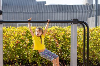 Yazın dışarıda oyun alanında eğlenen iki küçük tatlı kız. Çocuklar için spor aktiviteleri.