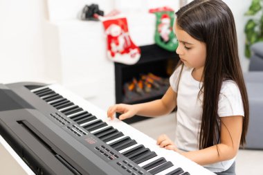 Küçük kız Noel 'de piyano çalıyor.