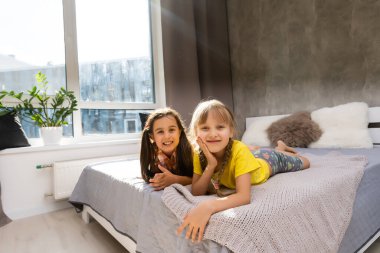 Küçük kız kardeşler birlikte yatakta.