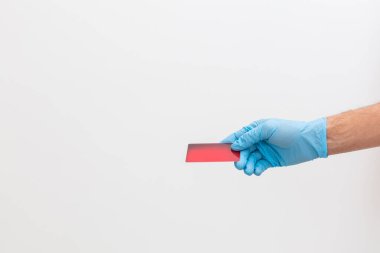 Kredi kartı tutan deri eldivenler, beyaz arka planda izole edilmiş.