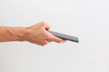 İzole edilmiş kadın eli beyaz ekranlı bir telefon tutuyor.