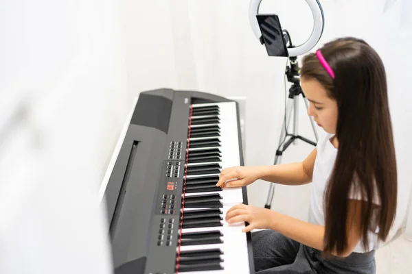 아이가 키보드 피아노 악기를 연주하고 비디오를 촬영하는 — 스톡 사진