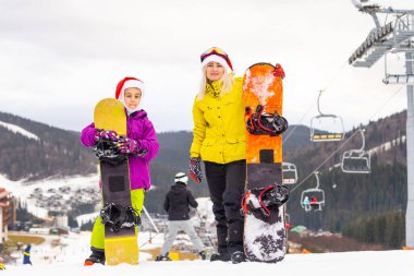 Kış zamanı ve kayak. Kayak ve snowboard yapan bir aile. Yüksek kalite fotoğraf