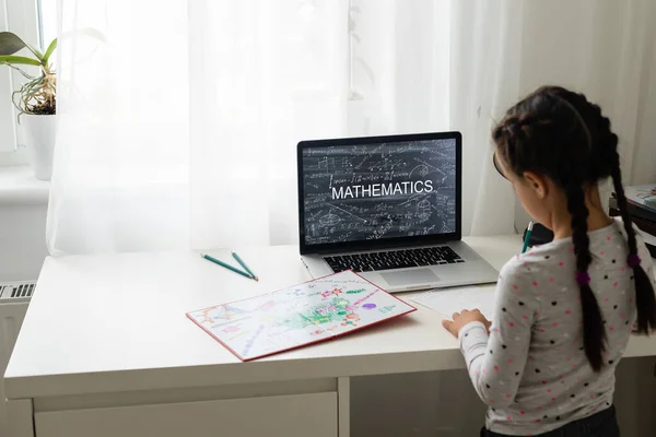 Dzieci uczą się online w domu. Kształcenie domowe i kształcenie na odległość dla dzieci. Dziewczyna student badania online z wideo nauczyciel połączeń. — Zdjęcie stockowe