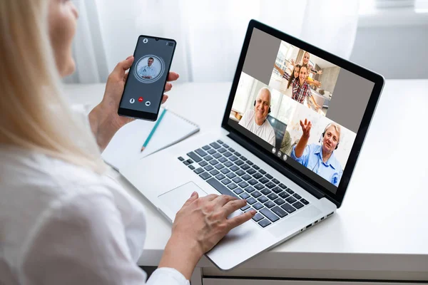 Back view of business woman talking to her colleagues about plan in video conference. Multiethnic business team using laptop for a online meeting in video call. Group of people smart working from home — Stock Photo, Image
