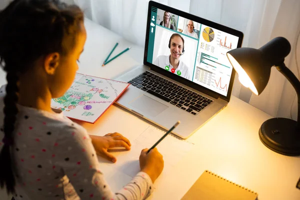 Gelukkig kind meisje met behulp van laptop voor online studeren. Het kind beantwoordt de vraag van de leraren. concept van online onderwijs — Stockfoto