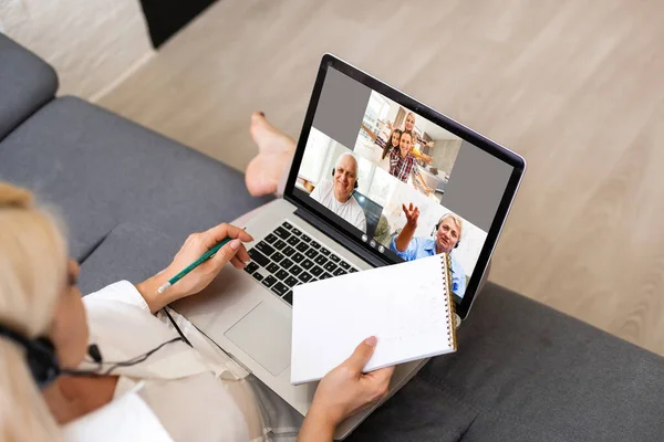 Back view of business woman talking to her colleagues about plan in video conference. Multiethnic business team using laptop for a online meeting in video call. Group of people smart working from home — Stock Photo, Image