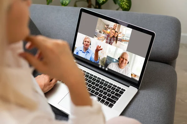 Vue arrière de femme d'affaires parlant à ses collègues au sujet du plan en vidéoconférence. Équipe d'affaires multiethnique utilisant un ordinateur portable pour une réunion en ligne en appel vidéo. Groupe de personnes intelligentes travaillant à domicile — Photo